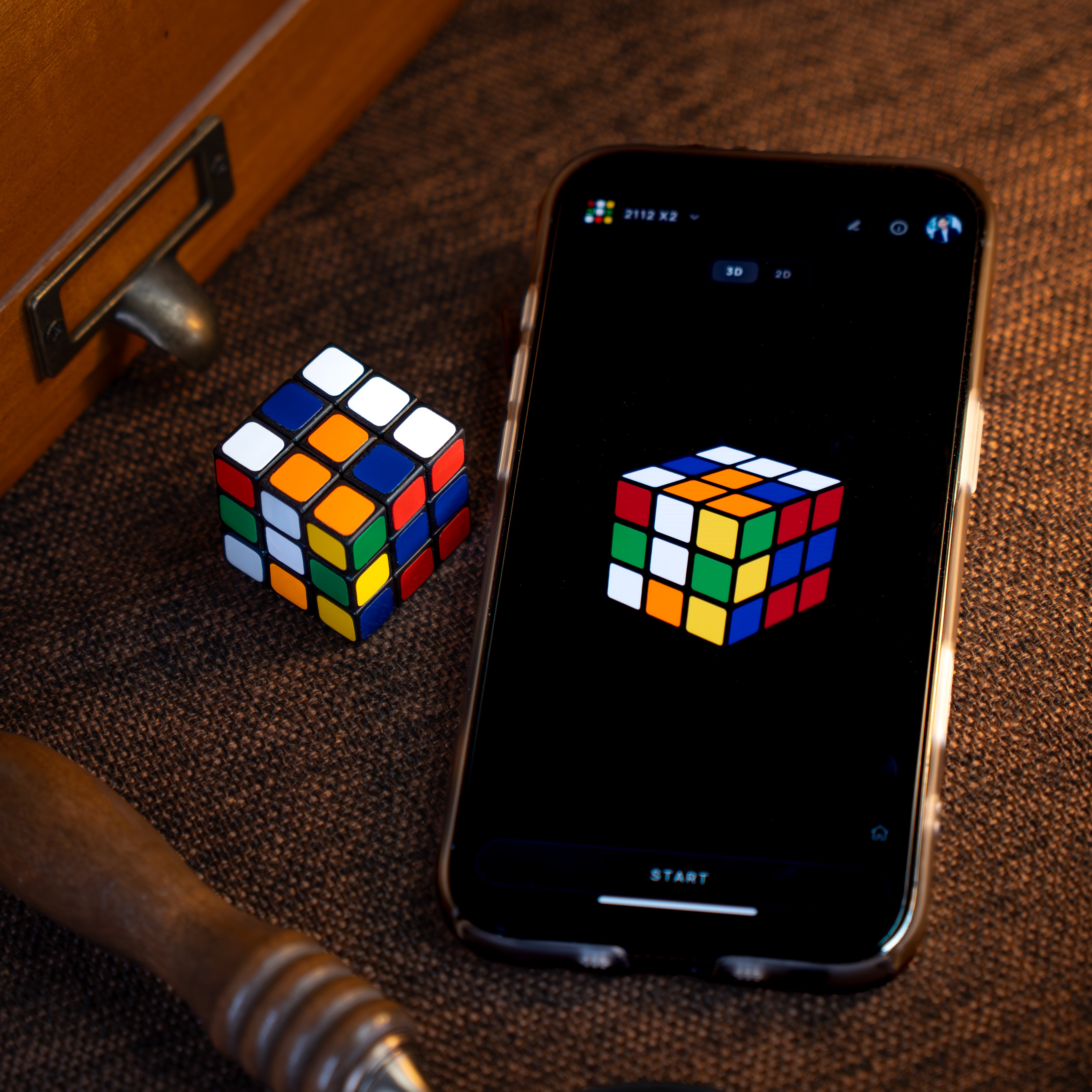 A physical cube next to Coincubed running on a phone